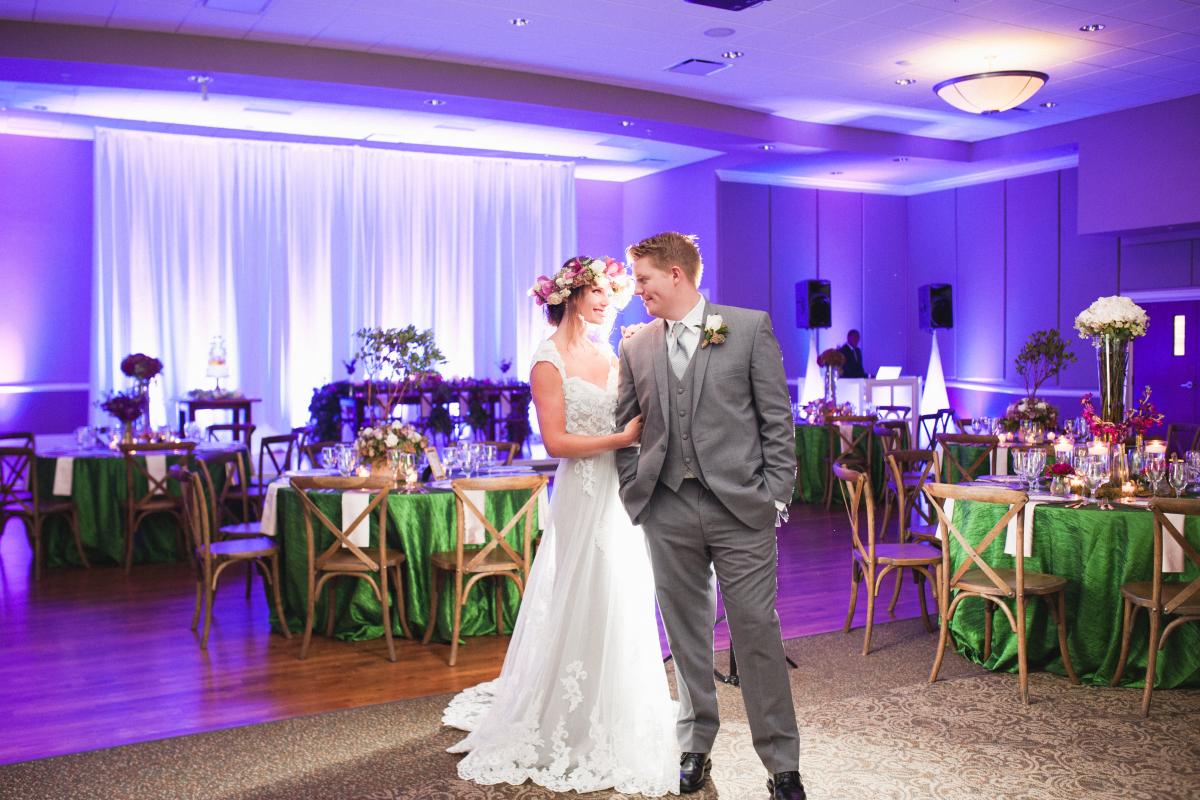 Bride and Groom in Grand Ballroom Decorated and Lit in Purple