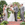 Bride, Groom, and Two Members of Wedding Party in Front of Wooded Archway